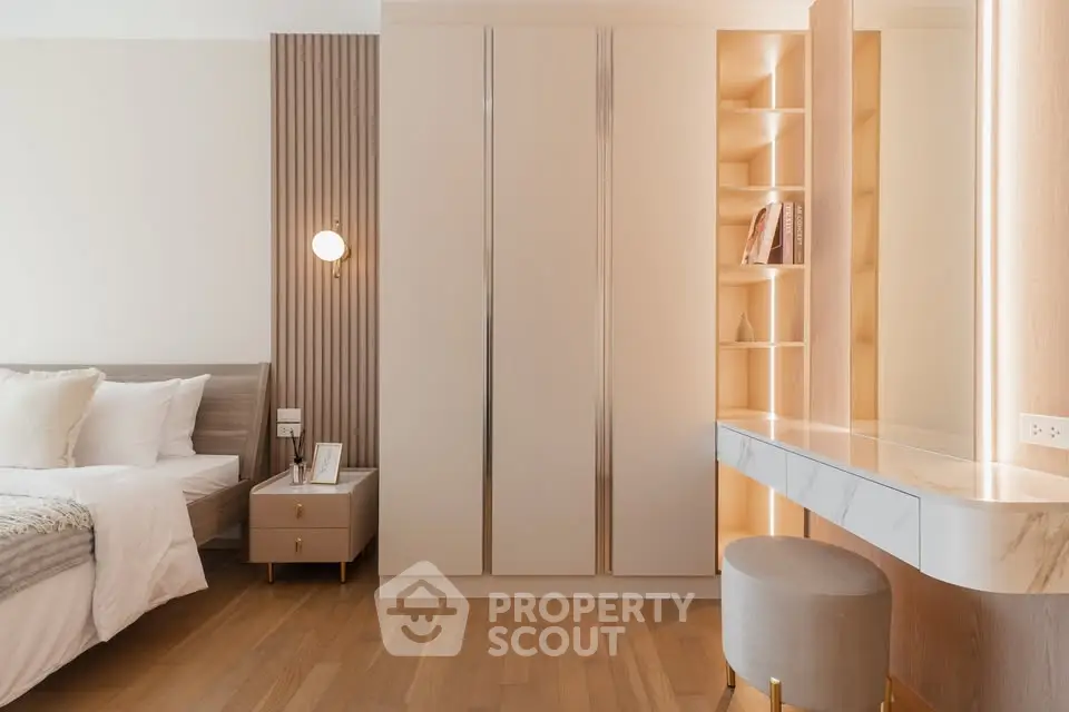 Elegant bedroom with modern design, featuring built-in wardrobe and stylish vanity area.