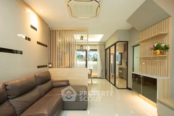 Modern living room with sleek design and open layout, featuring a comfortable leather sofa and stylish decor.