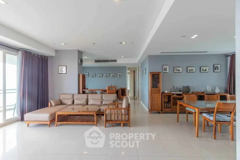 Spacious open-plan living and dining area with modern furniture and large windows.