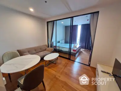 Modern studio apartment with glass partition, cozy living area, and stylish furnishings.