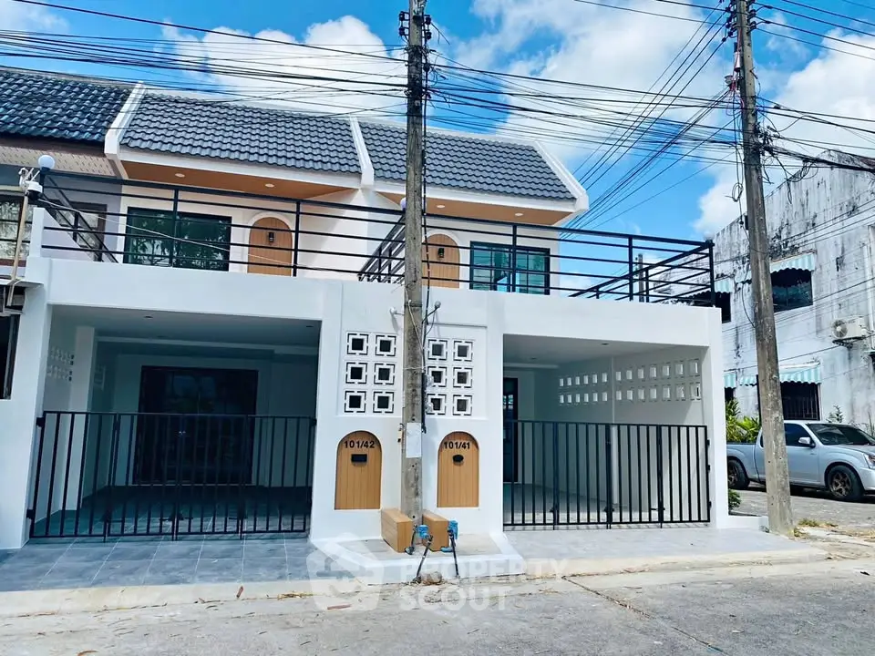Modern townhouse exterior with balcony and parking space, ideal for urban living.