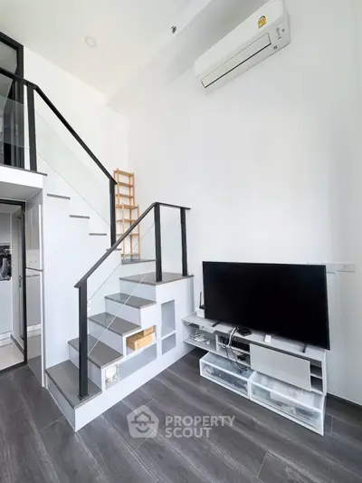 Modern living room with sleek staircase and entertainment center in stylish apartment