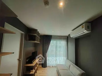 Modern living room with sleek design, featuring a cozy sofa, wall-mounted TV, and large window with curtains.
