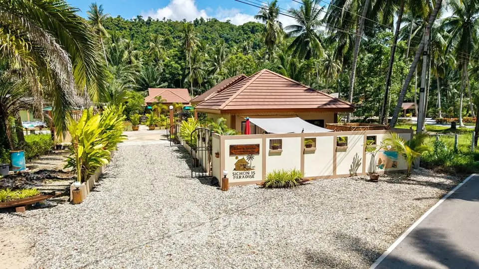 Charming tropical villa with lush garden and mountain backdrop, perfect for serene living.