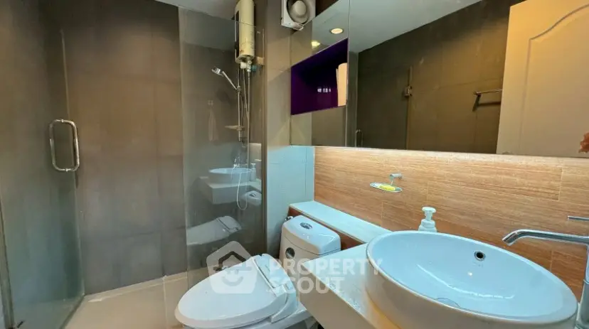 Modern bathroom with glass shower and stylish sink in contemporary home.