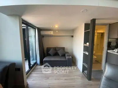 Modern living room with sleek design and balcony access, featuring a cozy sofa and stylish decor.