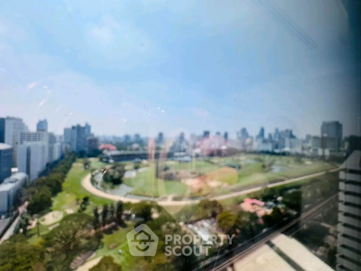 Stunning cityscape view from high-rise building with lush green park below, perfect for urban living.