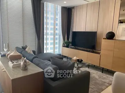 Modern living room with sleek furniture and large windows offering city views.