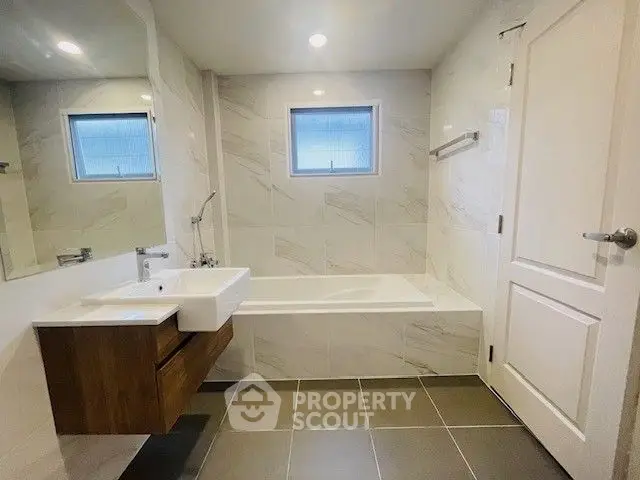Modern bathroom with sleek design and bathtub in a stylish real estate property.