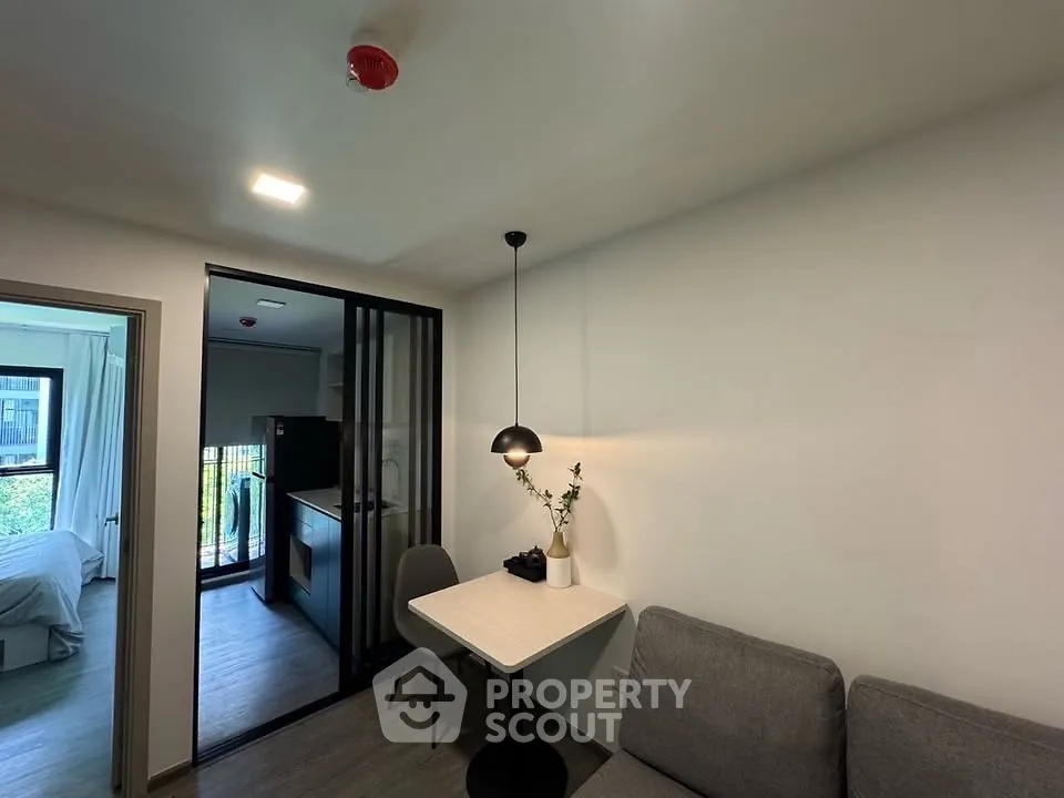 Modern apartment interior with cozy dining area and view into bedroom and kitchen.