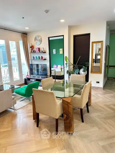 Stylish modern living room with glass dining table and city view, perfect for urban living.