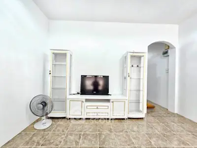 Bright living room with modern TV stand and glass cabinets, perfect for cozy entertainment setup.