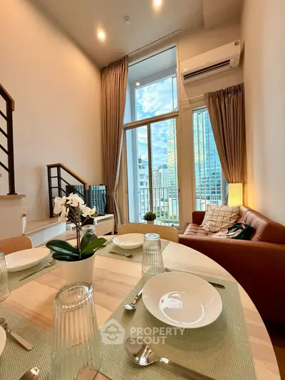 Modern living room with high ceilings and city view, featuring stylish furniture and dining area.