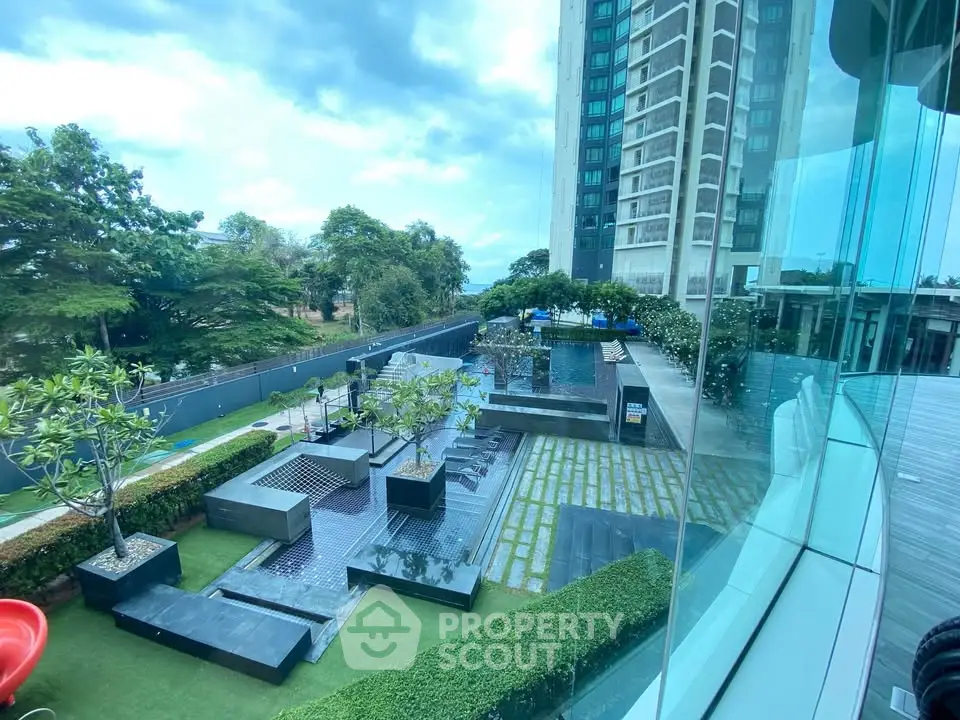 Luxurious high-rise building with modern outdoor pool and landscaped garden view.