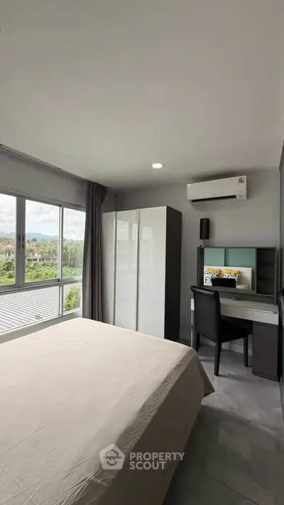 Modern bedroom with large window and scenic view, featuring a sleek desk and wardrobe.