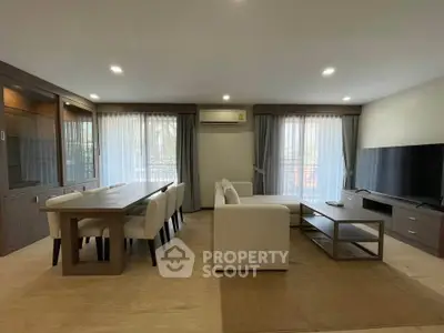 Spacious modern living room with elegant dining area and large windows for natural light.
