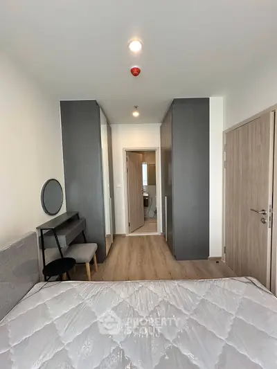 Modern bedroom with stylish furniture and ensuite bathroom in a contemporary apartment.
