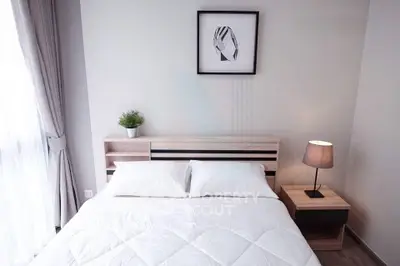 Modern bedroom with cozy bed, stylish lamp, and elegant decor in a bright, inviting space.