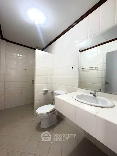 Spacious bathroom with modern fixtures and tiled walls in a contemporary home.