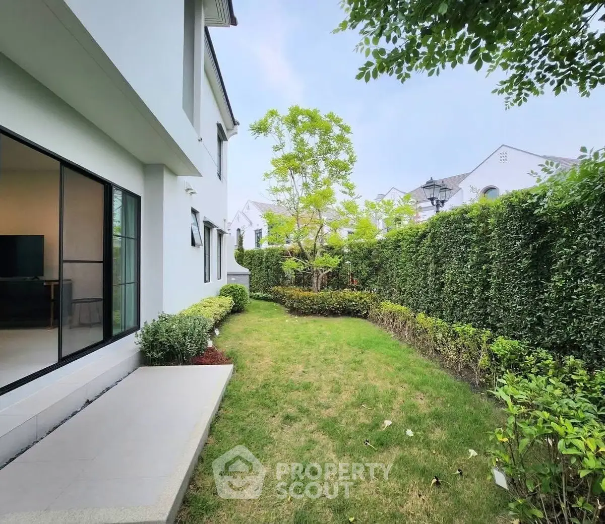 Charming garden view of modern home with lush greenery and spacious outdoor area.