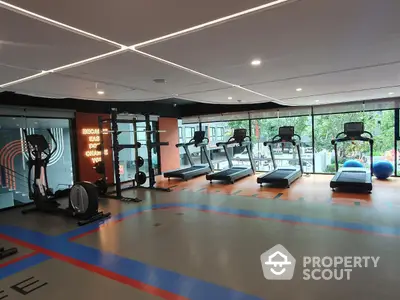 Modern gym with state-of-the-art equipment and large windows offering a scenic view.