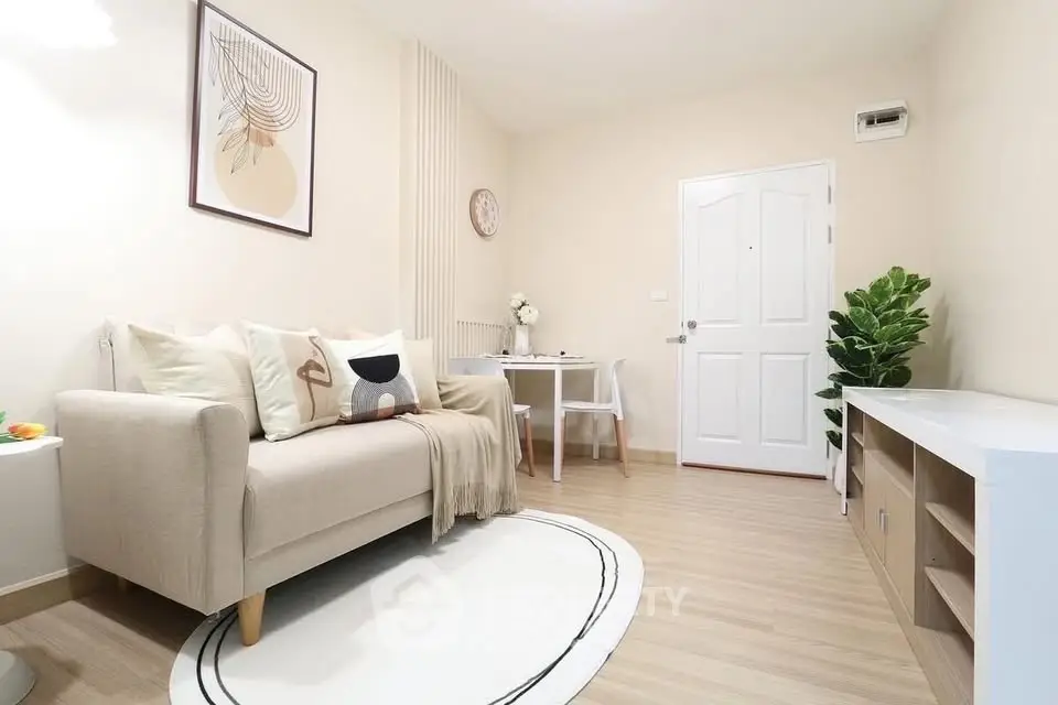 Modern living room with cozy sofa, stylish decor, and elegant wooden flooring.