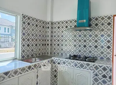 Charming kitchen with patterned tiles and modern gas stove in a cozy home setting.