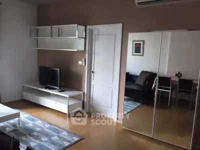 Modern living room with sleek furniture and mirrored wardrobe in stylish apartment.