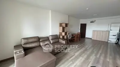 Spacious living room with modern furniture and wooden flooring in a contemporary apartment.