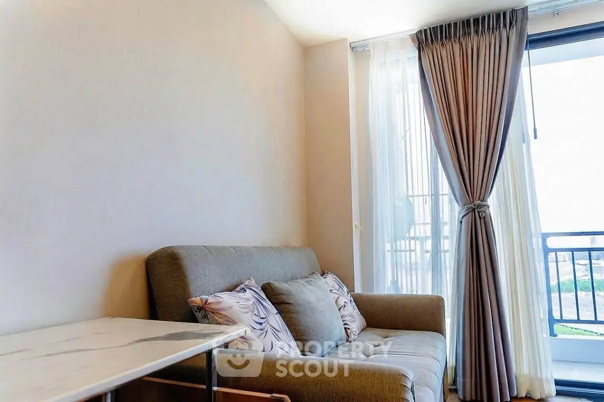 Cozy living room with elegant sofa and balcony view, perfect for relaxation and comfort.