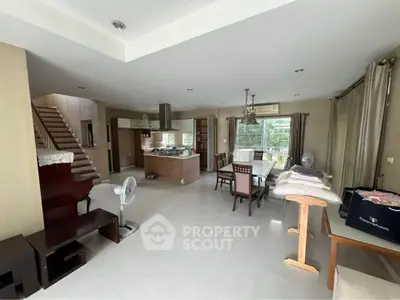 Spacious open-plan living and dining area with modern kitchen and staircase