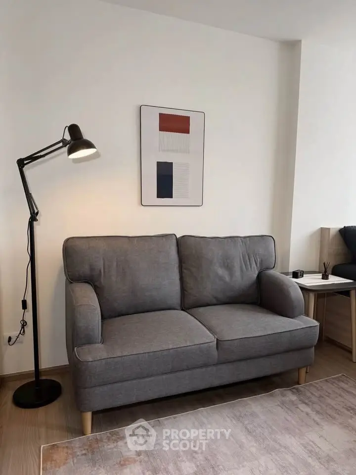 Modern living room with stylish gray sofa and floor lamp, perfect for cozy relaxation.