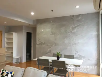 Modern dining area with sleek marble accent wall and stylish furniture