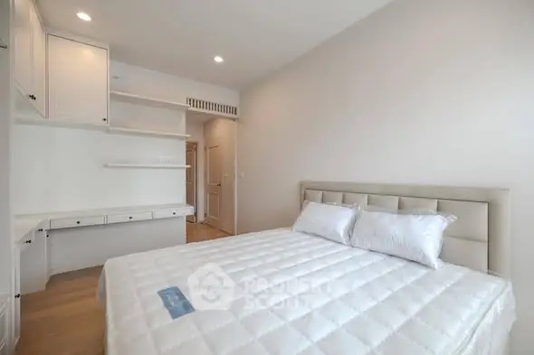 Spacious bedroom with modern design and ample storage in a bright apartment.