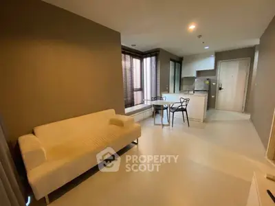 Modern open-layout living room with cozy sofa and stylish kitchen area