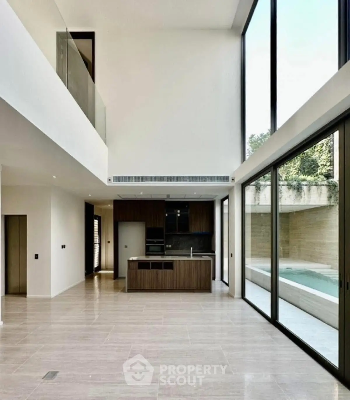 Spacious modern living room with floor-to-ceiling windows and pool view