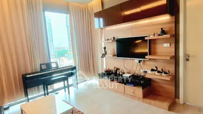Modern living room with piano and wall-mounted TV, featuring floor-to-ceiling windows and elegant decor.