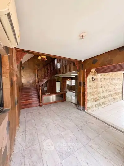 Spacious interior with elegant staircase and marble flooring in a luxurious home.