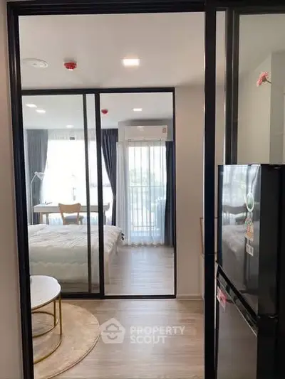 Modern apartment interior with glass sliding doors and cozy bedroom view.