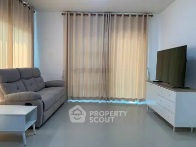 Modern living room with sleek furniture and large TV, perfect for relaxation.