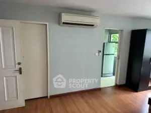Spacious room with wooden flooring and air conditioning, ideal for modern living.