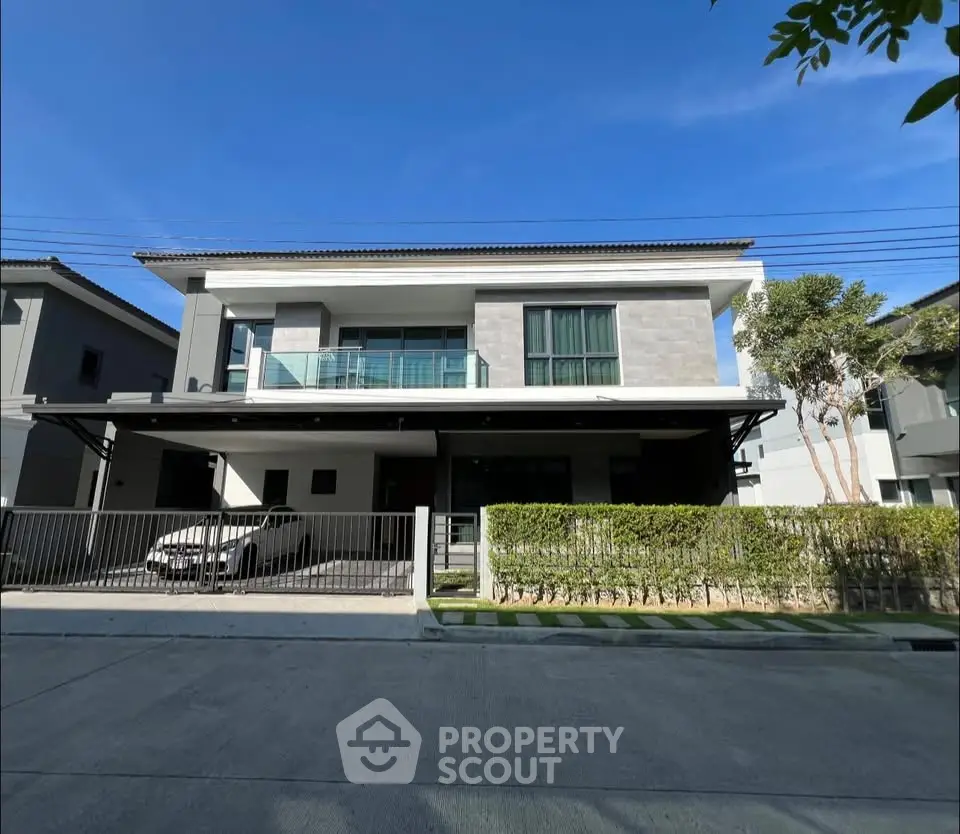 Modern two-story house with sleek design and spacious driveway in a serene neighborhood.