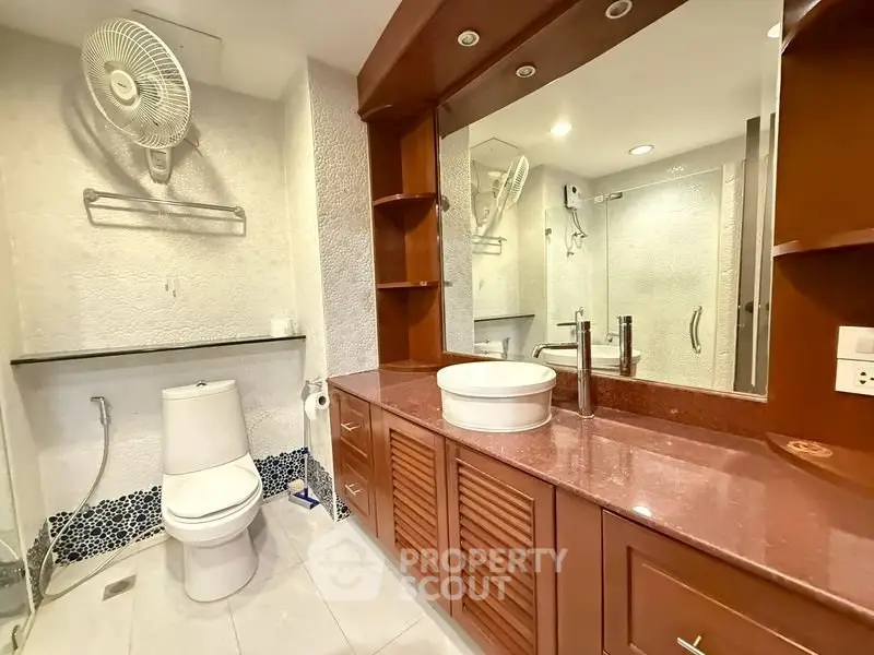 Spacious bathroom with modern fixtures and elegant wooden cabinetry