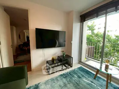 Modern living room with large TV and balcony view