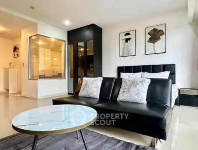 Modern living room with stylish decor and black leather sofa