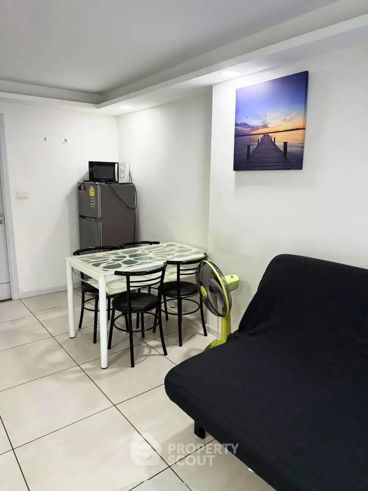 Cozy dining area with modern decor and compact kitchen appliances in a stylish apartment.