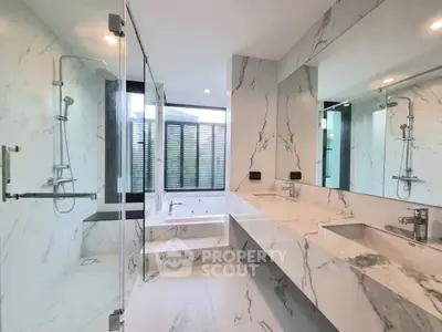 Luxurious marble bathroom with glass shower and modern fixtures