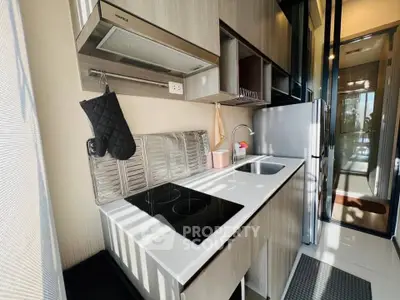 Modern kitchen with sleek design and electric cooktop in bright apartment