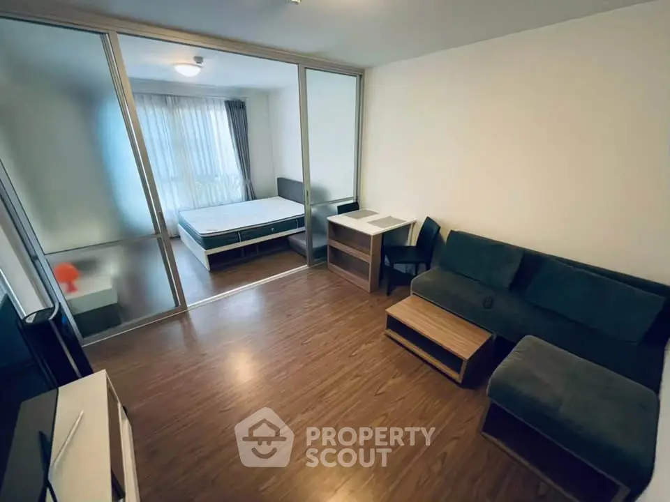 Modern studio apartment with sleek wooden flooring and cozy furnishings.