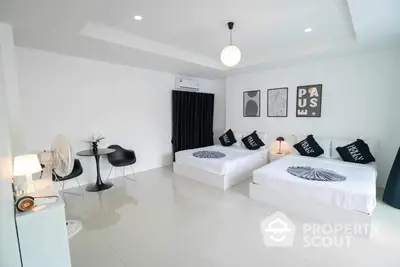 Spacious and modern bedroom with twin beds, sleek furniture, and artistic wall decor, perfect for a contemporary lifestyle.